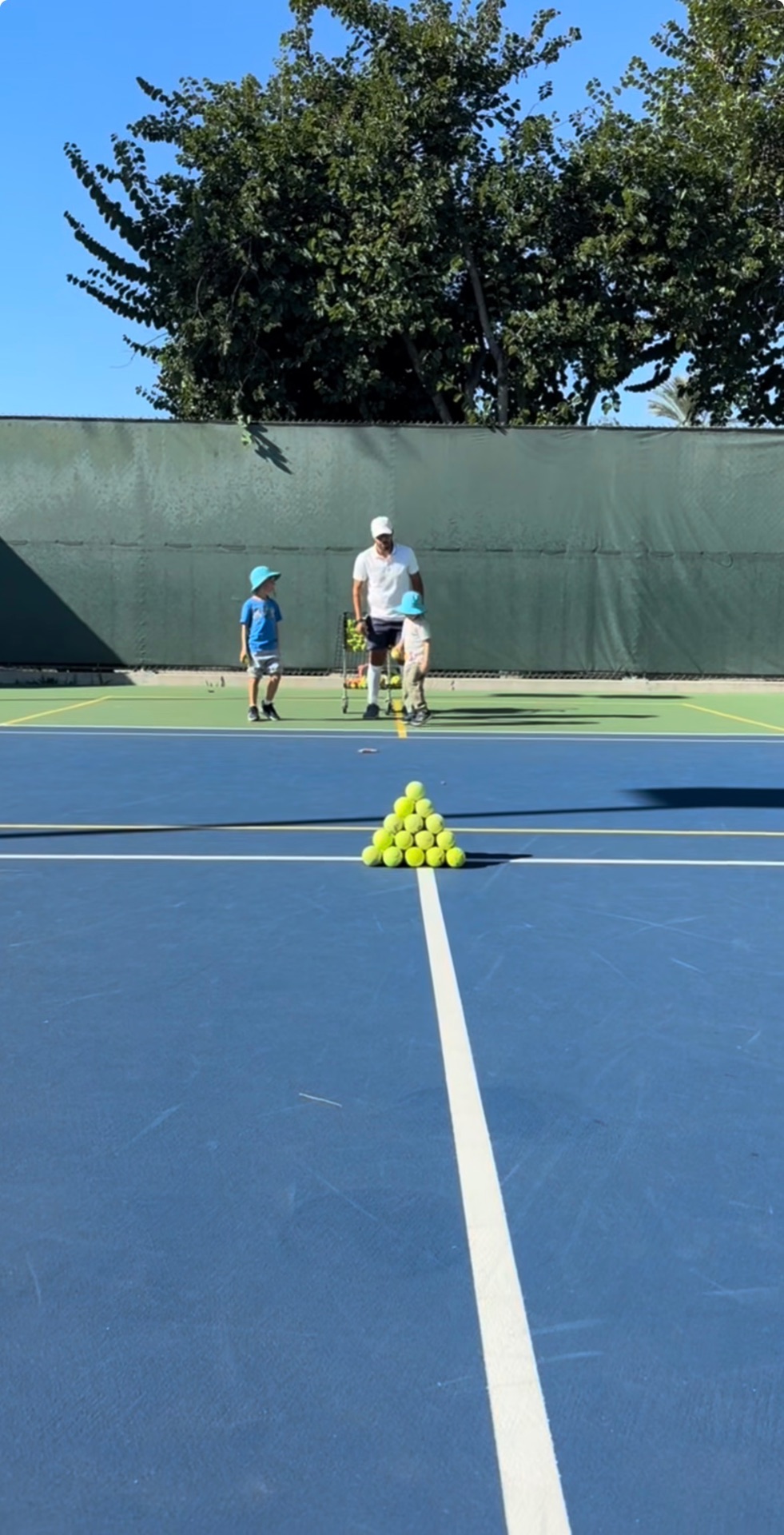 Ball pyramid with kids and coach in background