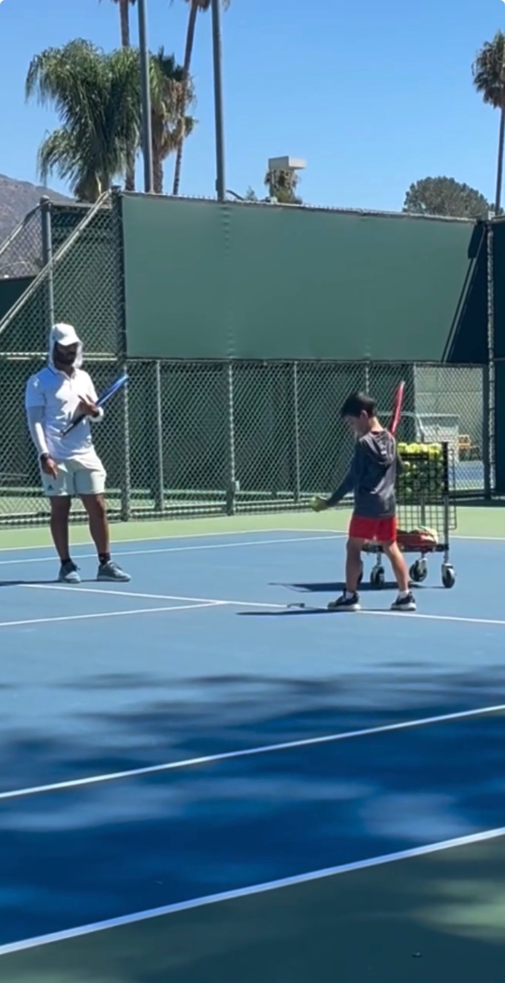 Coach guiding a junior player during practice